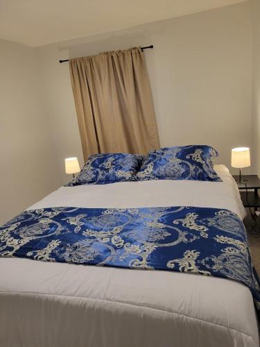 埃德蒙顿Furnished Room-5 Close to U of A in Edmonton - with Shared Spaces的床上有蓝色和白色的毯子