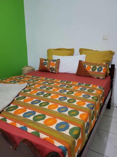 MamoudzouLE COROSSOL APPART的床上配有色彩缤纷的被子和枕头