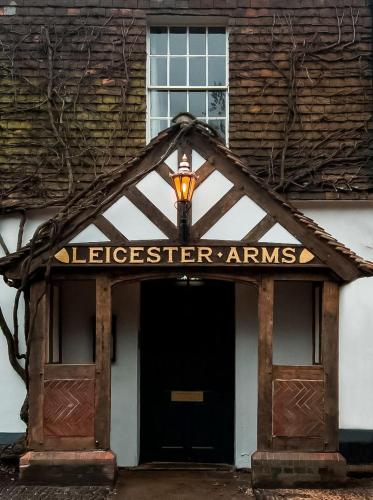 PenshurstThe Leicester Arms Country Inn的一座有标志的建筑,上面标有“stleeiger arramps”