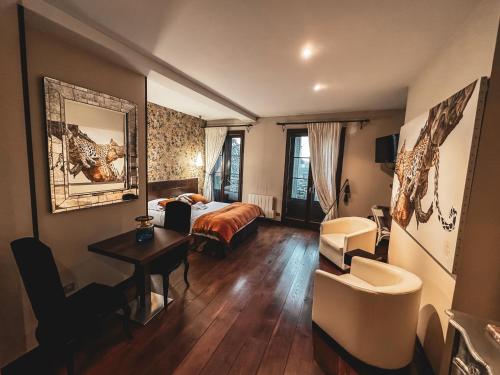 里摩日VILLA FLEURY - APPART'HÔTEL DE STANDING的酒店客房带一张床、一张桌子和椅子