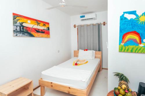 布韦朱TIKI Beach Club & Resort的一间设有一张床的客房,墙上挂着一幅画