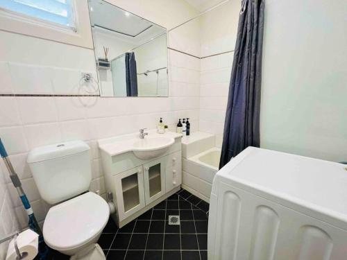 悉尼Opera & Harbour bridge view penthouse (3 rooms)的白色的浴室设有卫生间和水槽。