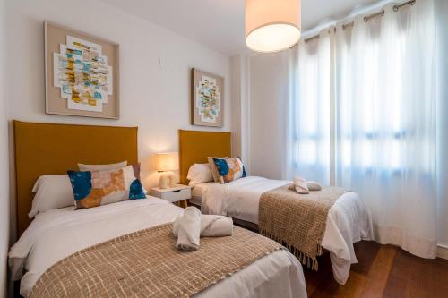 塞维利亚San Bernardo Home Free Parking的一间卧室设有两张床和窗户。