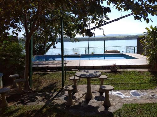 帕苏斯Recanto da Vandeka as margens do Rio Grande的游泳池前的桌子和凳子