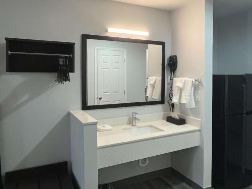 克莱尔莫尔Studio 6 Claremore OK的一间带水槽和大镜子的浴室