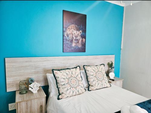 东伦敦Sea Breeze Manor - Aqua Unit的一间卧室配有一张蓝色墙壁的床