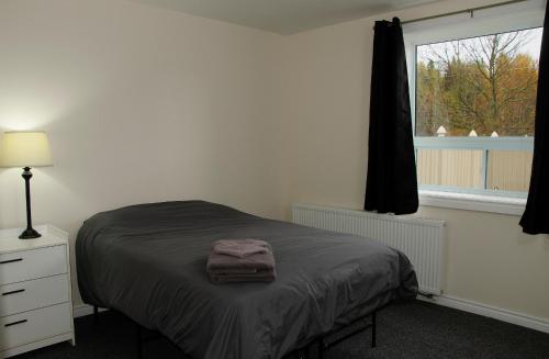 Kirkland LakeProspectors Inn的一间卧室配有一张床,床上有毛巾