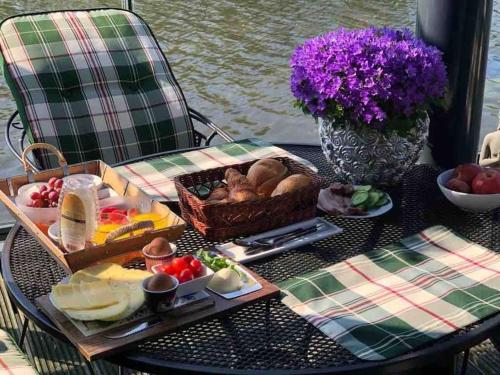 阿尔梅勒Prachtig guesthouse aan het water的一张桌子,上面放着一盘食物和一篮子食物