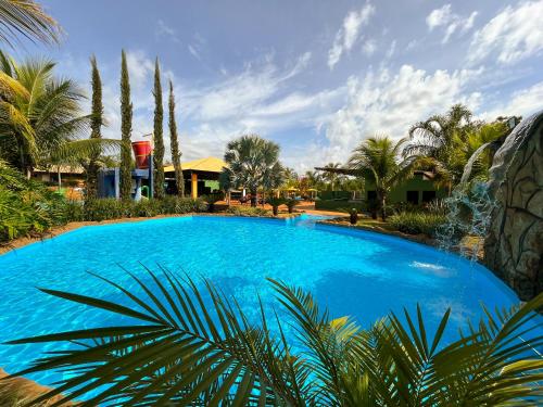 奥林匹亚Hotel Dolce Dulce的一座种植了棕榈树和房屋的大型蓝色游泳池