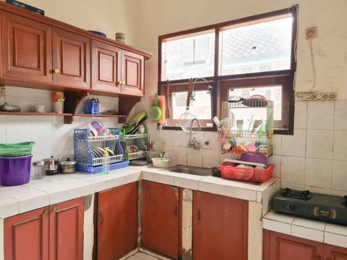 BontangHomestay Pesona Sintuk Bontang A9的厨房配有木制橱柜、水槽和窗户。