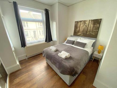 KentGravesend Spacious 2 bedroom Apartment - 2 mins to Town Centre and Train Station的一间卧室配有一张床,上面有两条毛巾