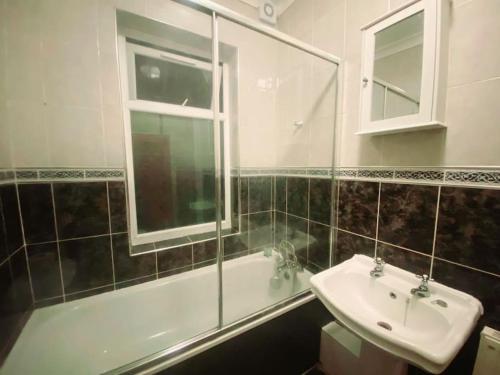 KentGravesend Spacious 2 bedroom Apartment - 2 mins to Town Centre and Train Station的一间带水槽、浴缸和镜子的浴室
