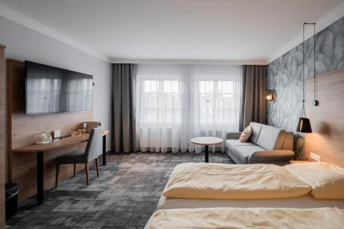 埃欣根Hotel Adler - Paulas Alb的配有一张床和一张书桌的酒店客房