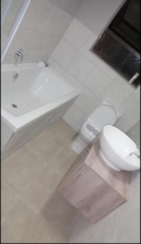 拉莫西Home away from Home in La Mercy的白色的浴室设有卫生间和水槽。