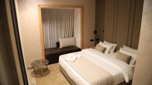 阿尤恩MH HOTEL LA CASA的卧室配有白色的床和椅子