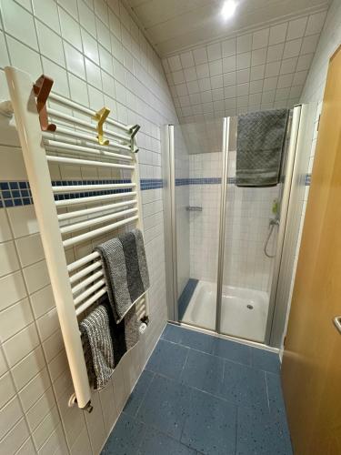GoldkronachGemütliches Appartement - WBS的带淋浴和毛巾的白色瓷砖浴室