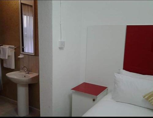 哈博罗内Keeme-Nao Self Catering Apartments的浴室设有一张带水槽和镜子的床