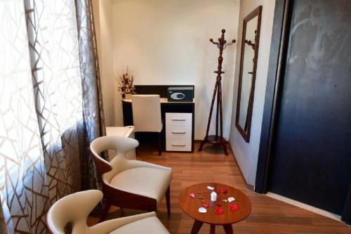 El MadaniaHOTEL IKRAM EL DHAYF的配有椅子、桌子和书桌的房间