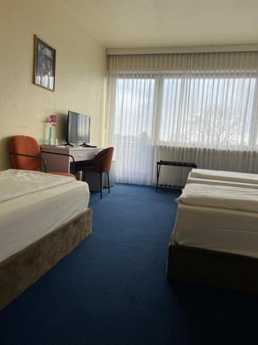 科隆弗洛翰芬酒店的酒店客房配有两张床和一张书桌