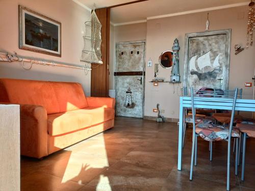马里纳·迪·比萨Casa Vacanze Marina di Pisa Catola的客厅配有橙色沙发和桌子