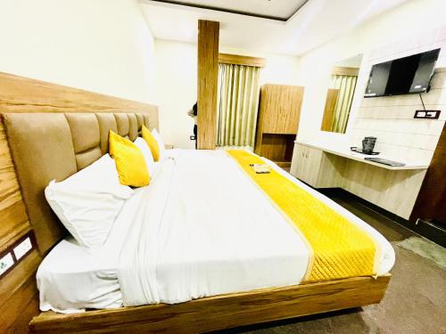 马图拉Hotel Superhouse by Wisdom Madhav的一间卧室配有一张带黄色枕头的大床