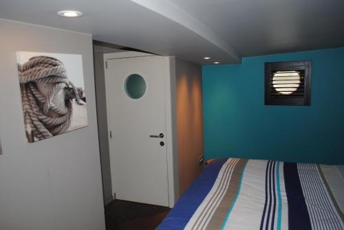 根特Boat & Breakfast Bellevue的一间卧室设有一张床和蓝色的墙壁