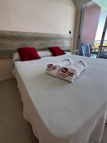 拉帕洛马Audencia del Mar的一张配有红色和白色枕头的大床