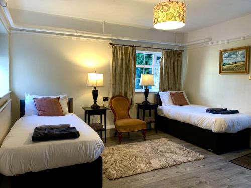 马基特雷森Moortown House的酒店客房,配有两张床和椅子