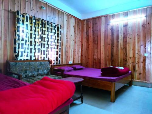 拉塔古里Hotel Green Gold Resort Lataguri的一间设有两张床和一张沙发的房间