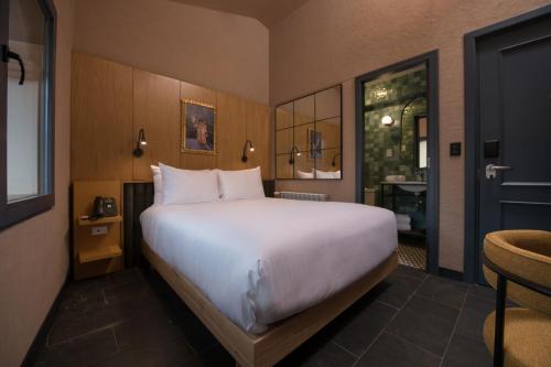库斯科Motto By Hilton Cusco的一间带白色大床的卧室和一间浴室
