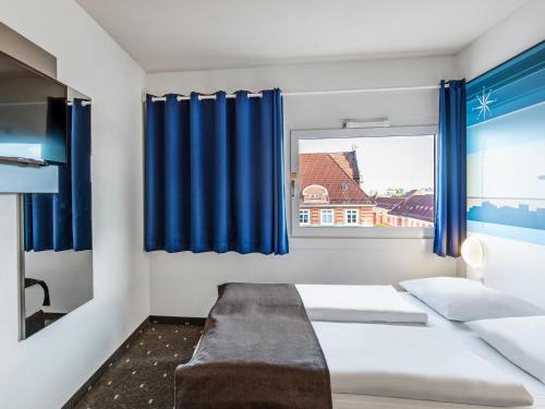 汉堡汉堡-阿尔托那B&B酒店的一间卧室配有床和蓝色窗帘的窗户