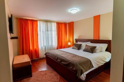 巴尼奥斯Casita Linda Baños的一间卧室配有床和橙色窗帘的窗户