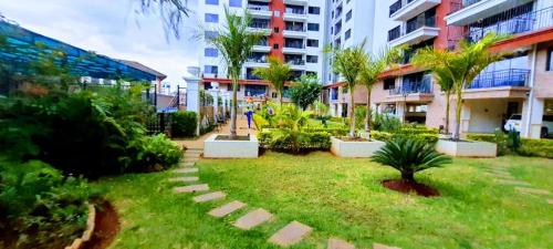 内罗毕the perfect affordable apartments的一座花园,在一座建筑的中间种有棕榈树