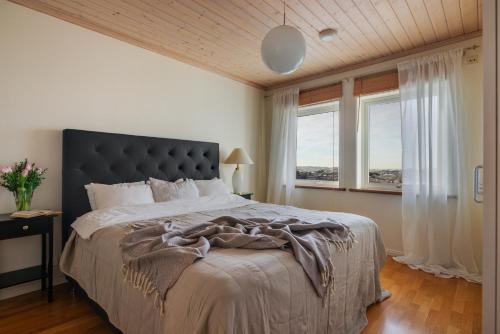 弗加尔巴卡Vetteberget Huset的一间卧室设有一张大床和两个窗户。