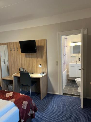 赫尔辛格斯堪地亚酒店的酒店客房设有一张桌子、一张床和一间浴室。