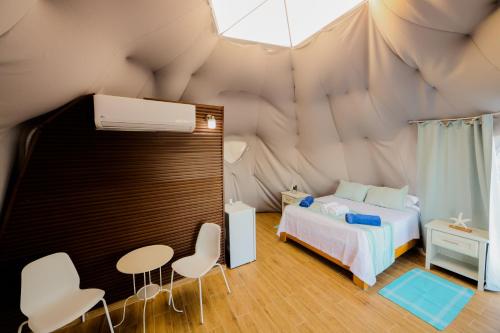 蓬塔露奇亚Hotel Don Bululo Camping Lodge的帐篷内一间卧室,配有一张床和椅子