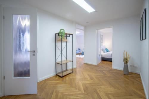 德累斯顿CoView - ruhige Design Wohnung - 2 Schlafzimmer - voll ausgestattete Küche的走廊上设有白色墙壁和木地板的房间