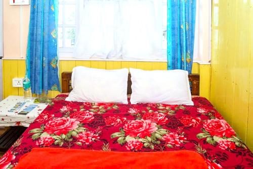 大吉岭Hotel New Smriya Homestay Inn Darjeeling的一张床上铺有红色的毯子,上面有红玫瑰