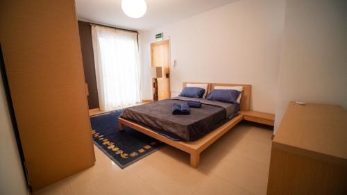 梅利哈Mellieha Bay 3 Bedroom Apartment ''Coastal Comfort''的一间卧室配有一张带蓝色枕头的大床