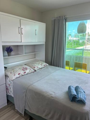 嘎林海斯港Studio A completo 400m da praia的一间卧室配有一张带2条蓝色毛巾的床