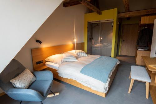 韦尼格罗德Gästehaus Liebfrauen的一间卧室配有一张大床和一把椅子