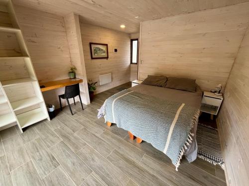 皮奇勒姆VIENTO BRAVO的卧室配有木墙内的一张床