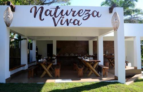 伊塔卡雷Pousada Natureza Viva的木桌和椅子餐厅标志