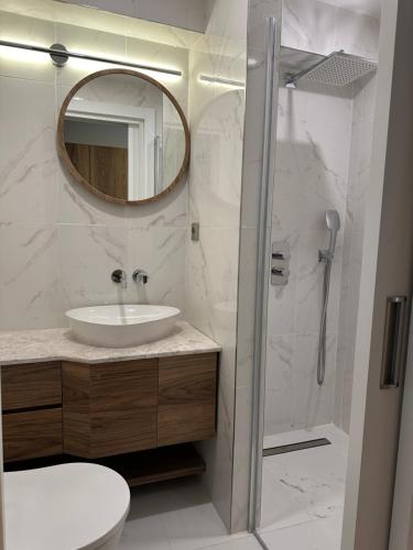 伊斯坦布尔Iris Han Hotel的浴室配有盥洗盆和带镜子的淋浴