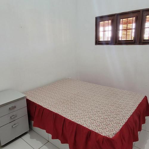 蒂鲍Casa em Tibau RN的一间卧室配有一张床、一个梳妆台和两个窗户。