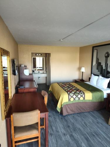 朗维尤Arya Inn & Extended Stay的配有一张床和一张书桌的酒店客房