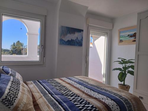 萨阿拉德洛斯阿图内斯ATLANTERRA PUEBLO的一间卧室,配有床、窗户和植物