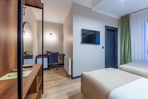 ArnavutköyLenora Airport Hotel的配有一张床和一张书桌的酒店客房