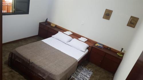 圣代佩德罗Quarto Quádruplo的一间卧室配有一张带木制床头板的床