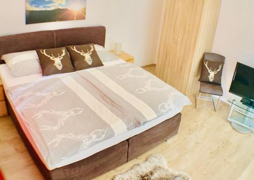 维尔芬翁Alpen Appartements Oberlehengut - HIDEAWAY的一间卧室配有一张带毯子和椅子的床